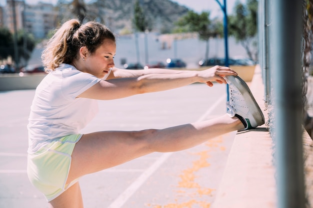 Kostenloses Foto flexible junge frau, die bein ausdehnt