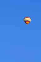 Kostenloses Foto fliegender mehrfarbiger ballon im strahlend blauen himmel
