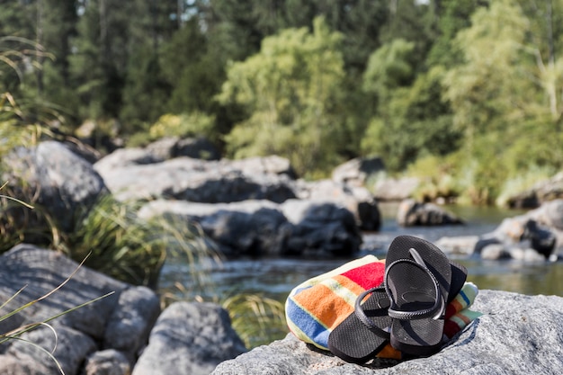 Kostenloses Foto flipflops an der steinküste in der nähe von wasser