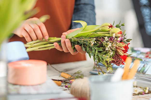 Florist bei der Arbeit: die weiblichen Hände der Frau, die Mode modernen Blumenstrauß von verschiedenen Blumen macht