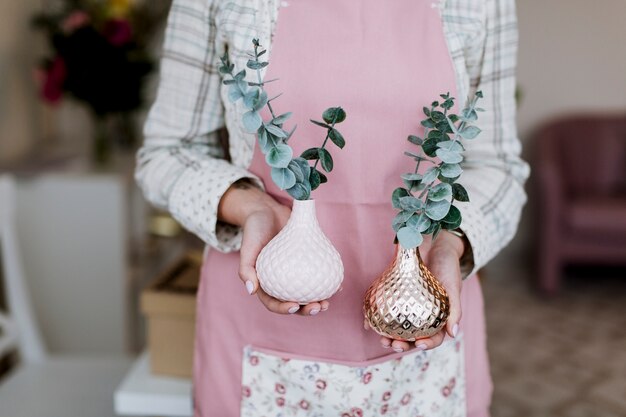 Florist, der Anlagen in den Vasen hält