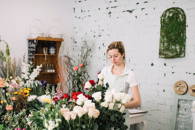 Florist, der Blumensträuße am Tisch macht