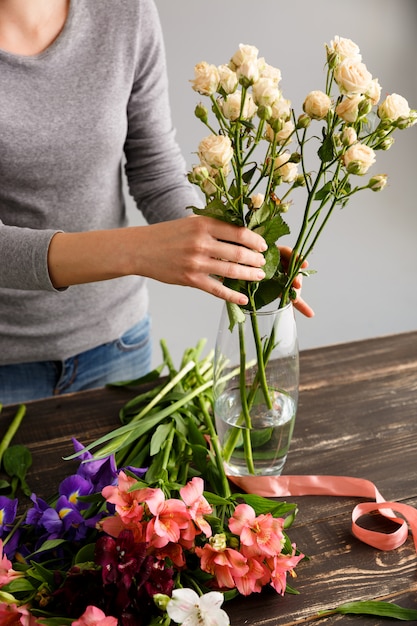 Florist, der Blumenstraußblumen in der Vase macht