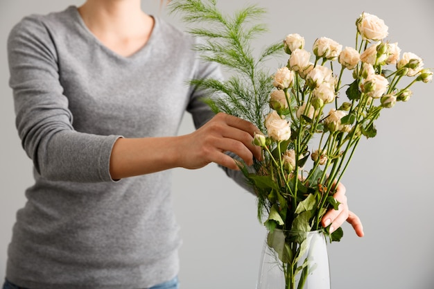 Florist, der Blumenstraußblumen in der Vase macht