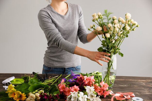 Florist, der Blumenstraußblumen in der Vase macht