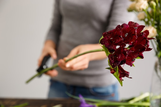 Florist, der Blumenstraußblumen in der Vase macht