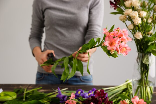 Florist, der Blumenstraußblumen in der Vase macht