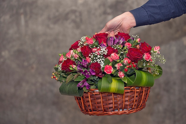 Florist, der einen mischblumenkorb fördert.