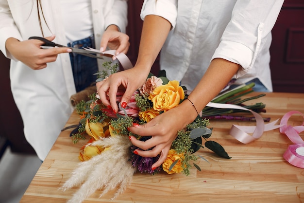 Kostenloses Foto florist macht einen schönen blumenstrauß in einem studio