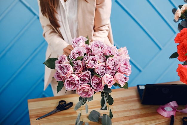 Florist macht einen schönen Blumenstrauß in einem Studio