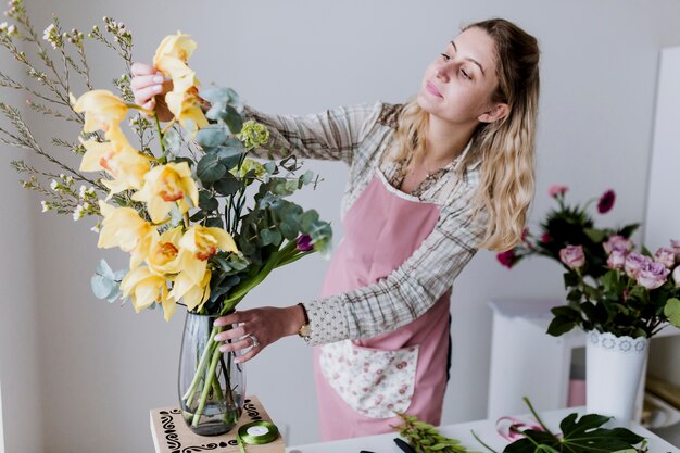 Floristenfrau, die gelbe Blumen nimmt