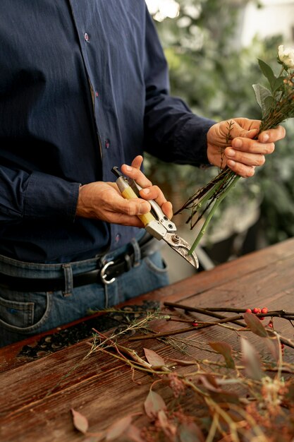 Floristenmann, der die Blumenstiele schneidet