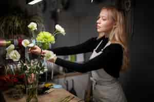 Kostenloses Foto floristin, die ein schönes blumenarrangement macht