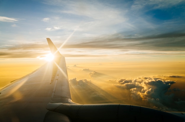 Flügel des Flugzeuges am blauen Himmel in der Dämmerung und Sonnenuntergang