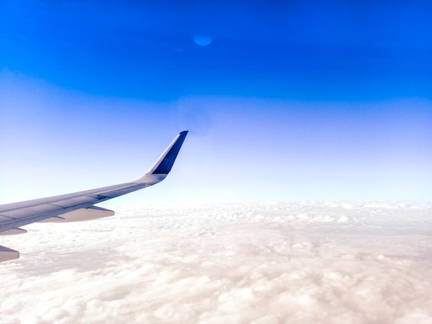 Flügel des flugzeugs auf hintergrund des blauen himmels