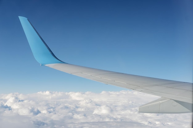 Flugzeugflügelansicht vom Flugzeugfensterplatz Blauer Himmel und Wolke