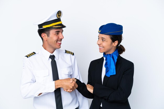 Flugzeugpilot und mixed race stewardess isoliert auf weißem hintergrund handshake nach gutem deal