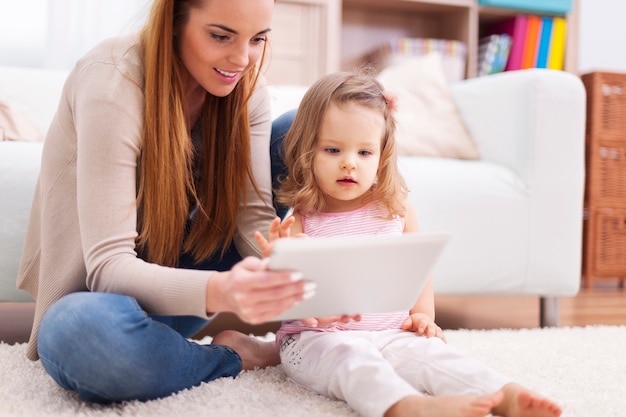 Fokussieren Sie Frau mit kleinem Mädchen unter Verwendung der digitalen Tablette