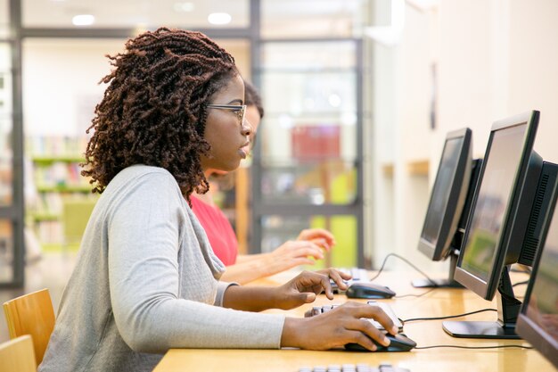 Fokussierte Studentin aufgeregt mit Onlinetest