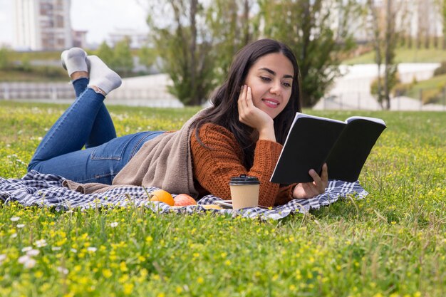 Fokussierte Studentin, die draußen für Test studiert