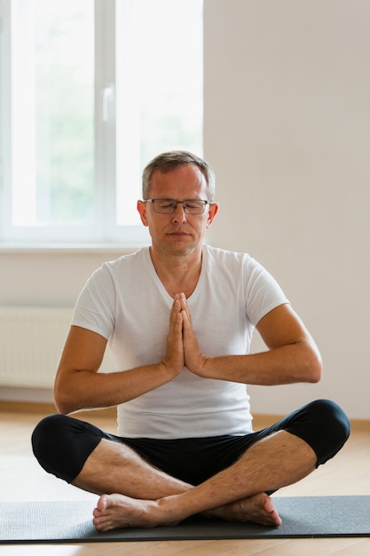 Fokussierter älterer Mann, der Yoga tut