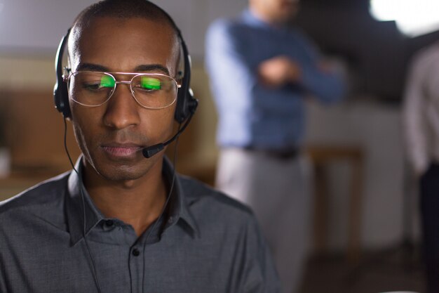 Fokussierter Afroamerikanermann mit dem Kopfhörer, der unten schaut