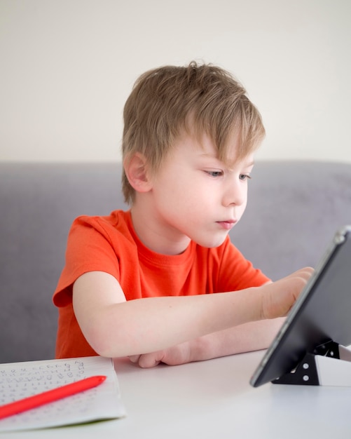 Fokussierter Kinderjunge mit einem digitalen Tablet