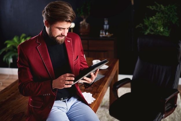 Fokussierter Mann, der im Home Office mit digitalem Tablet arbeitet