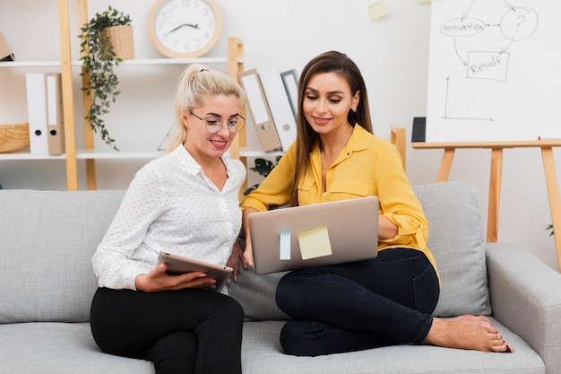 Kostenloses Foto formale gekleidete frauen der vorderansicht, die auf laptop schauen