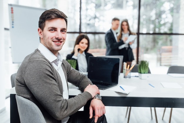 Foto am erfolgreichen gutaussehenden Geschäftsmann mit seinem Team, das im Büro arbeitet.