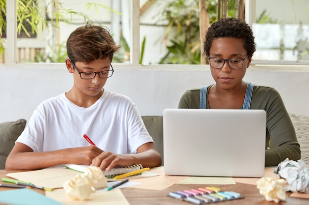 Foto der dunkelhäutigen Frau sitzt vor geöffnetem Laptop