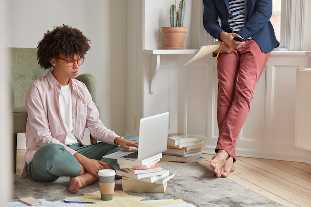 Foto der ernsthaften jungen Studentin hat Afro-Frisur