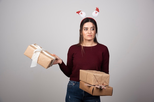 Foto der Frau, die Stirnband trägt und Geschenke hält.