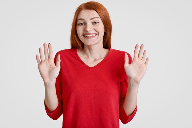 Foto der freudigen sommersprossigen Frau mit den langen roten Haaren