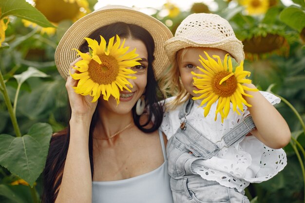 Foto der glücklichen Familie. Mutter und Tochter. Familie zusammen im Sonnenblumenfeld.