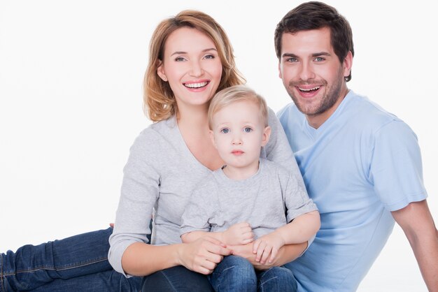 Foto der glücklichen jungen Familie mit sitzendem kleinen Kind