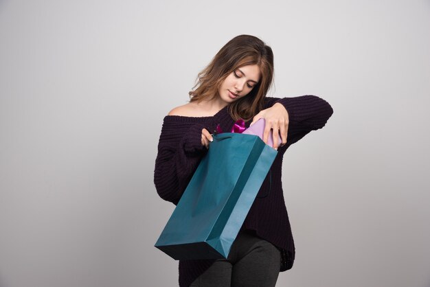 Foto der jungen Frau mit Einkaufstaschen.