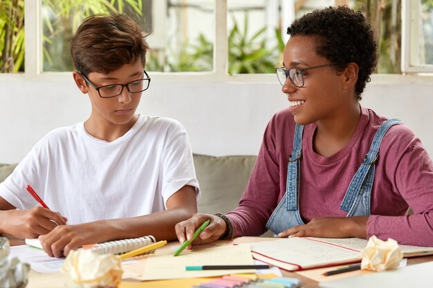 Foto der jungen Frauen der gemischten Rasse sitzen zusammen am Tisch