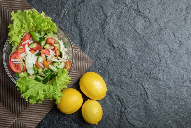 Foto des gesunden veganen Salats auf schwarzem Hintergrund. Hochwertiges Foto