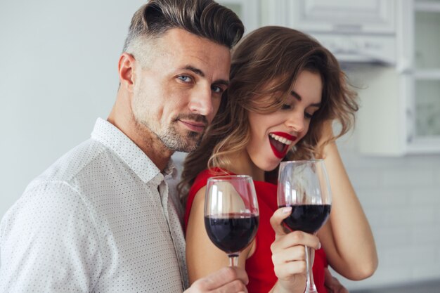 Foto des gutaussehenden Mannes umarmen seine Frau beim Weintrinken