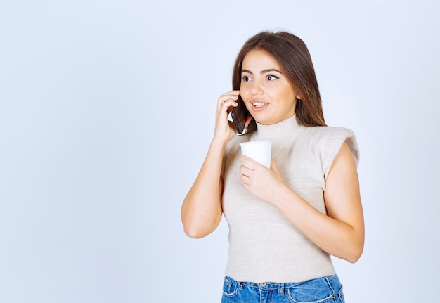 Foto des hübschen Frauenmodells, das am Telefon steht und spricht.