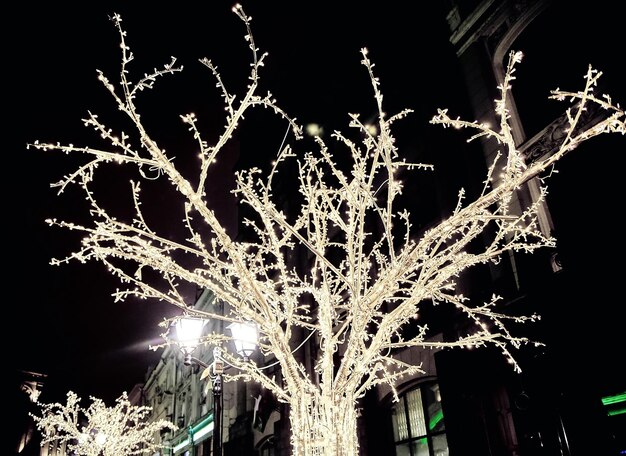 Foto des Straßenhintergrundes in der verschneiten Nacht mit Weihnachtslichtern