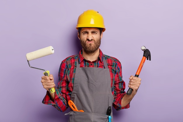 Foto des unzufriedenen männlichen Baumeisters grinst Gesicht mit unglücklichem Ausdruck