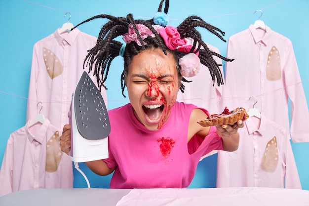 Foto einer emotionalen Hausfrau mit Marmelade im Gesicht