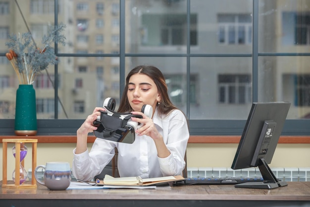 Kostenloses Foto foto einer jungen dame, die ein vr-gerät hält und es betrachtet