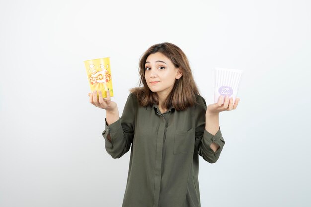 Foto einer jungen Frau in Freizeitkleidung mit Popcorn. Foto in hoher Qualität