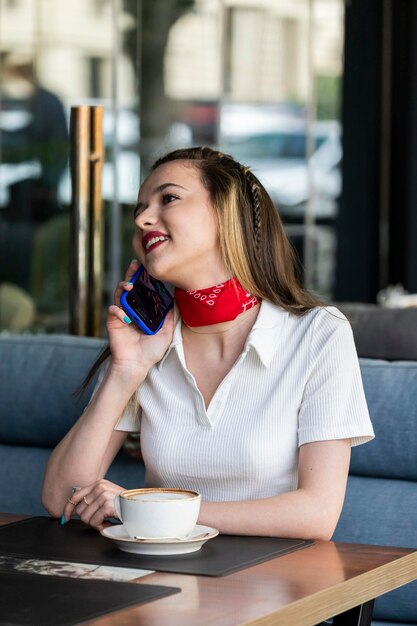 Foto einer schönen Dame, die im Restaurant sitzt und telefoniert