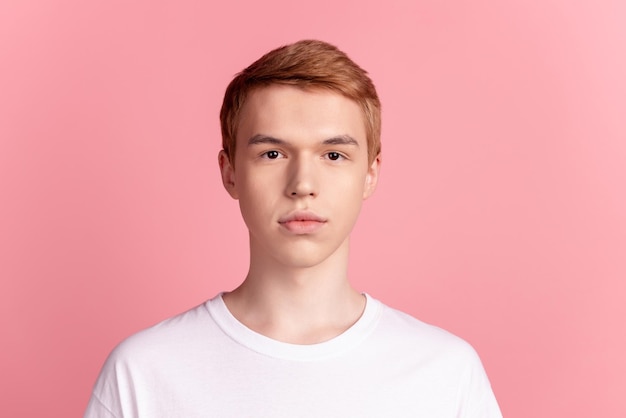 Foto eines jungen gutaussehenden kerls, der ernsthaftes selbstbewusstes, intelligentes, lässiges outfit isoliert auf rosafarbenem hintergrund trägt