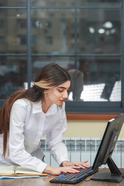 Foto eines jungen schönen Mädchens, das am PC arbeitet