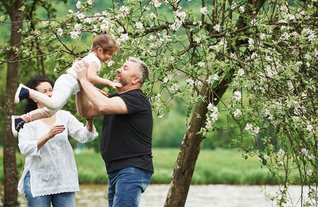 Foto in Bewegung. Fröhliches Paar genießt schönes Wochenende im Freien mit Enkelin. Gutes Frühlingswetter